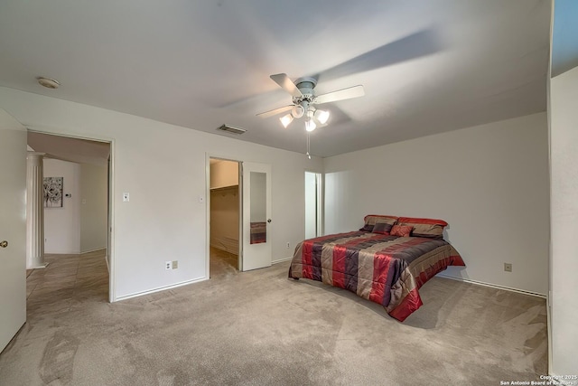 carpeted bedroom with ceiling fan, a spacious closet, and visible vents