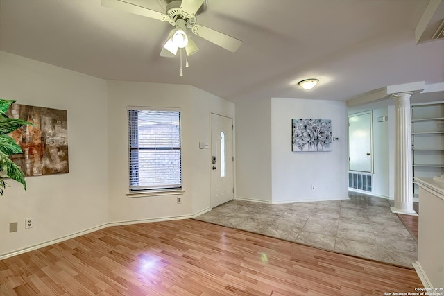 interior space featuring ceiling fan, decorative columns, baseboards, and light wood-style flooring