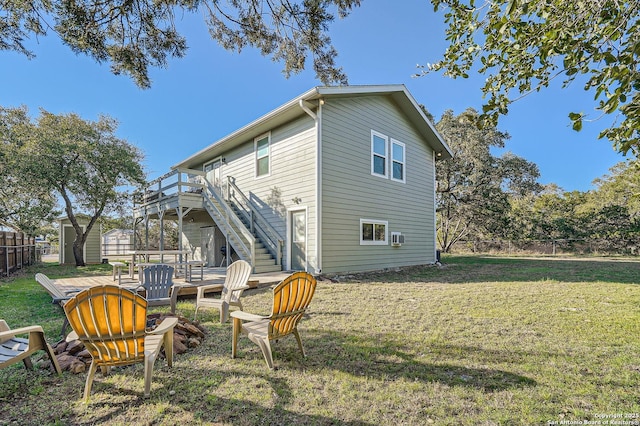 rear view of house with a lawn, stairway, an outbuilding, fence, and a shed