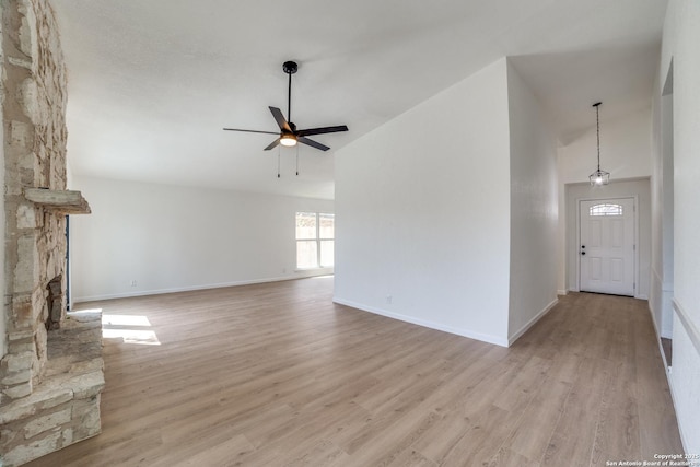 unfurnished living room with ceiling fan, high vaulted ceiling, wood finished floors, and baseboards