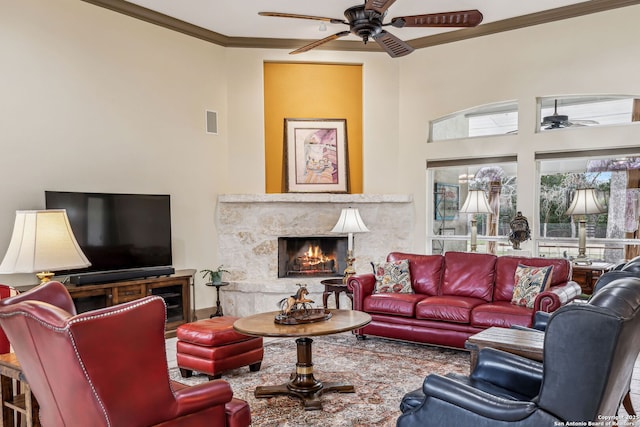 living room featuring ceiling fan, ornamental molding, a premium fireplace, and visible vents