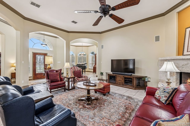 tiled living area with ornamental molding, arched walkways, and visible vents