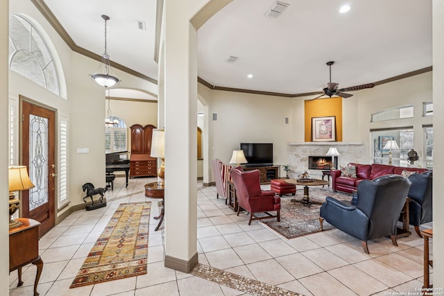 living area featuring baseboards, light tile patterned flooring, visible vents, and a healthy amount of sunlight