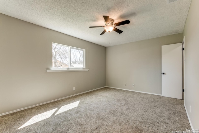 empty room featuring baseboards, a textured ceiling, a ceiling fan, and carpet flooring