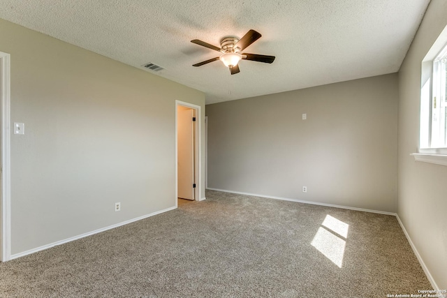 unfurnished room featuring a textured ceiling, baseboards, visible vents, and a ceiling fan