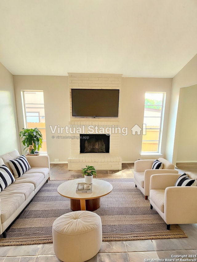 living room with vaulted ceiling, a fireplace, and baseboards