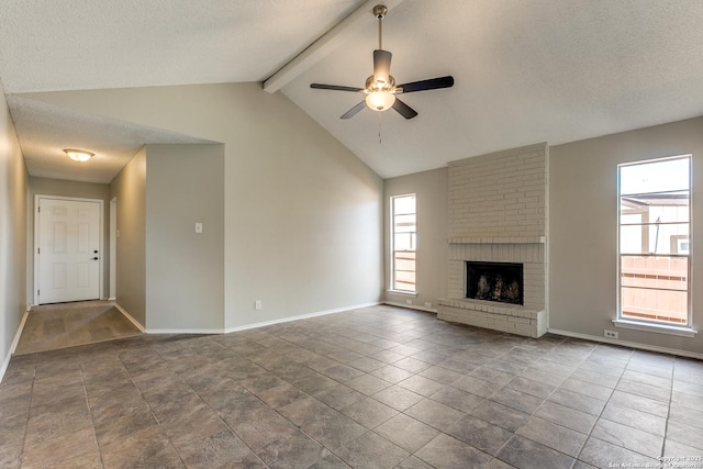 unfurnished living room featuring a brick fireplace, vaulted ceiling with beams, a textured ceiling, and baseboards