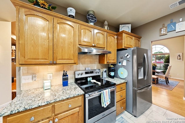 kitchen with visible vents, decorative backsplash, appliances with stainless steel finishes, light stone countertops, and under cabinet range hood