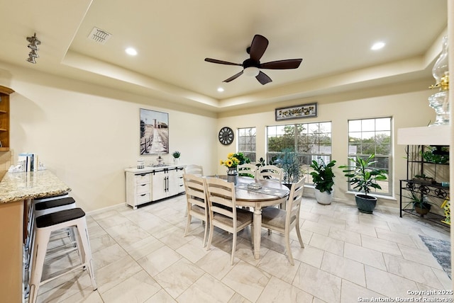 dining area featuring ceiling fan, recessed lighting, beverage cooler, visible vents, and a raised ceiling