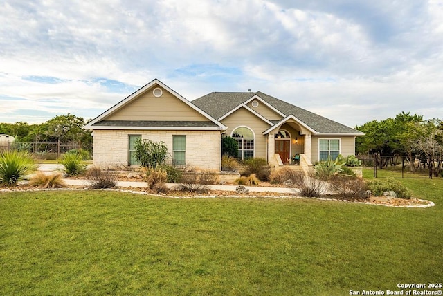 ranch-style home featuring a front yard, roof with shingles, and fence