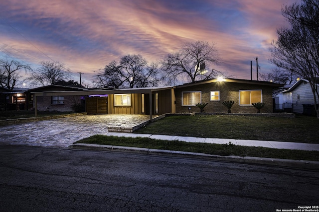 view of front facade featuring brick siding and a lawn