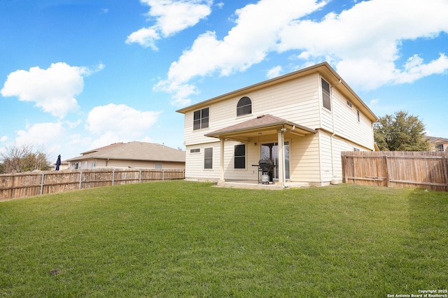 rear view of property featuring a yard, a patio, and a fenced backyard