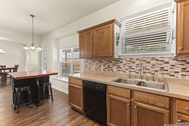 kitchen with black dishwasher, dark wood finished floors, tasteful backsplash, and a sink