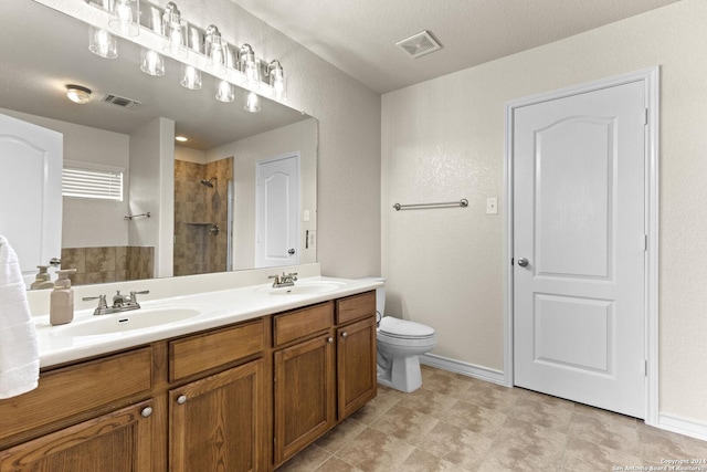 bathroom featuring visible vents, a sink, and tiled shower