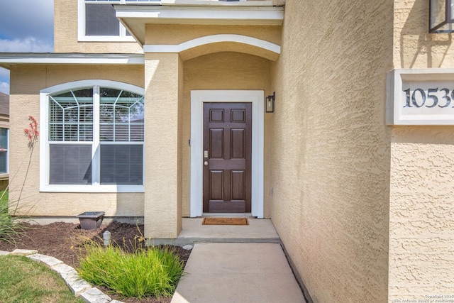 doorway to property featuring stucco siding