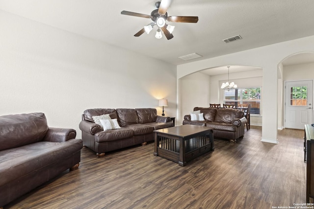 living room featuring arched walkways, dark wood-style flooring, visible vents, baseboards, and ceiling fan with notable chandelier