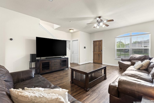 living room featuring a textured ceiling, ceiling fan, wood finished floors, and baseboards