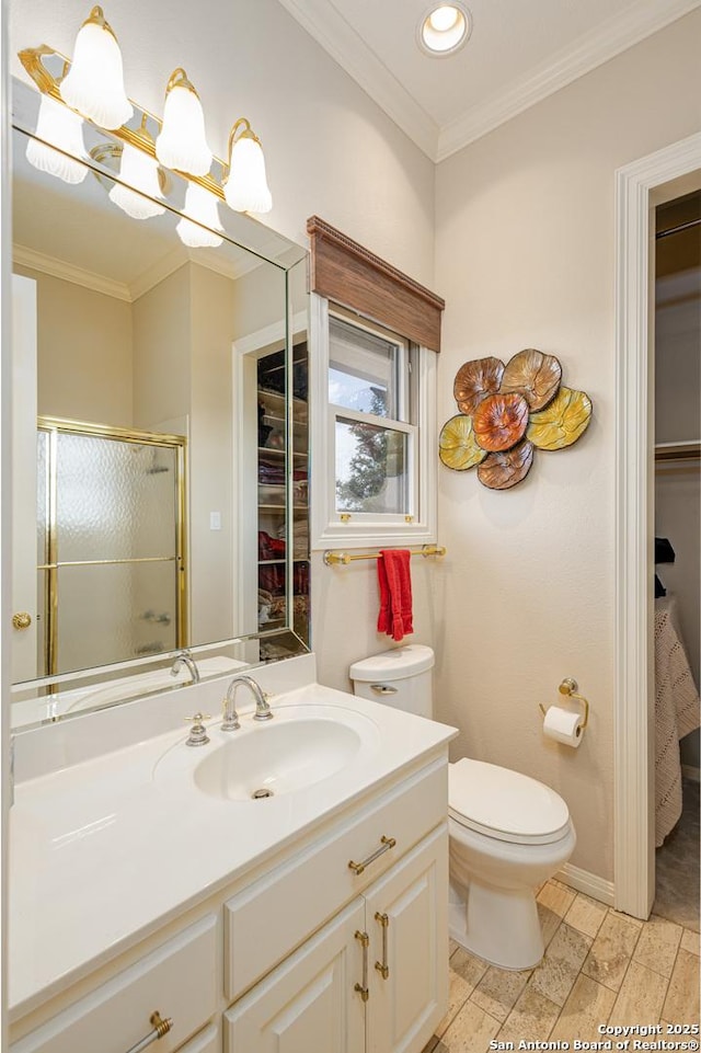 bathroom featuring a stall shower, toilet, crown molding, vanity, and a chandelier