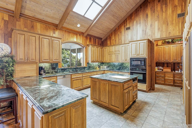 kitchen featuring wooden walls, a peninsula, a skylight, black appliances, and beamed ceiling