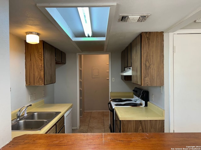 kitchen with range with electric stovetop, light countertops, visible vents, a sink, and under cabinet range hood