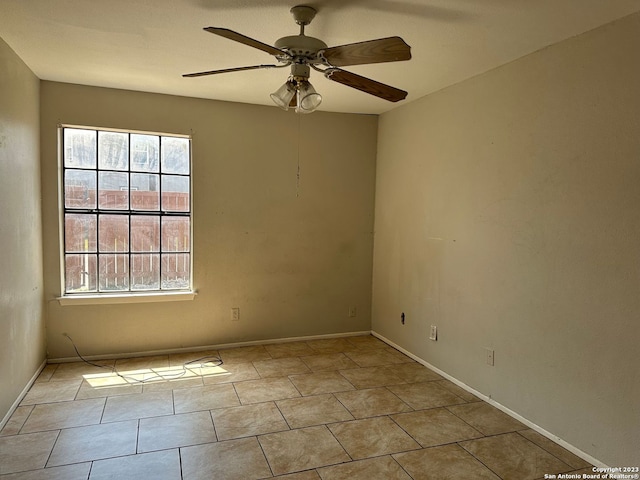 unfurnished room featuring ceiling fan, baseboards, and tile patterned floors