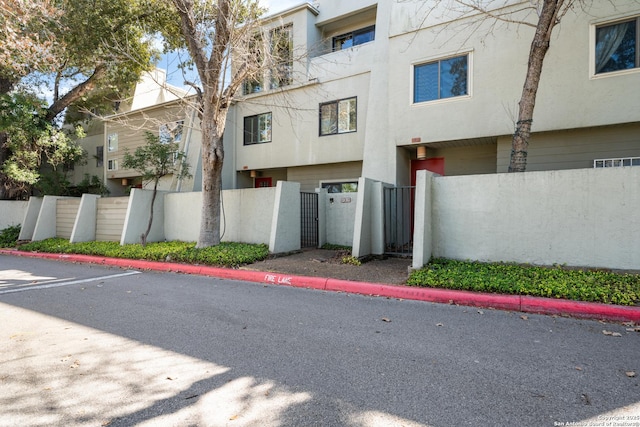 view of property with a fenced front yard and uncovered parking