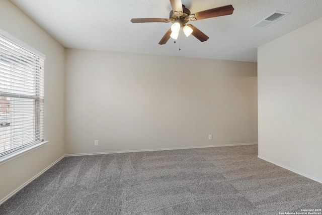 empty room featuring a textured ceiling, carpet flooring, and visible vents