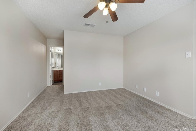 unfurnished bedroom with light carpet, a textured ceiling, visible vents, and baseboards