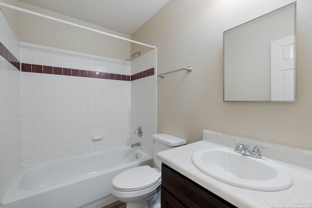 full bathroom with bathing tub / shower combination, a textured ceiling, toilet, and vanity