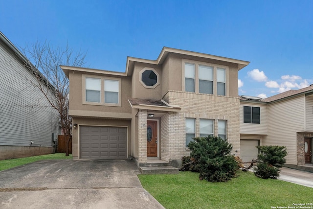 view of front of home with a garage, brick siding, driveway, stucco siding, and a front yard