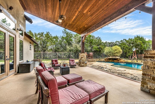 view of patio / terrace featuring a fenced backyard, a fenced in pool, and french doors