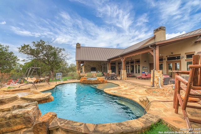 view of pool featuring a pool with connected hot tub, a patio area, and an outdoor living space