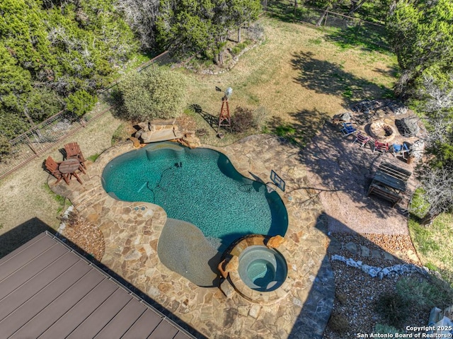 outdoor pool with fence and an in ground hot tub