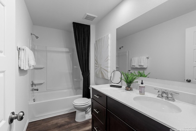 full bathroom with visible vents, toilet, wood finished floors, shower / bath combo with shower curtain, and vanity