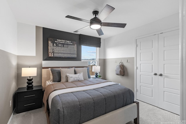 carpeted bedroom featuring ceiling fan, a closet, and baseboards