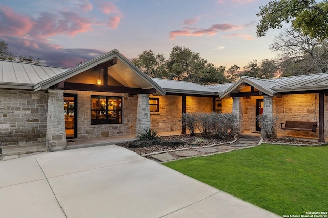 view of front of property with metal roof, a standing seam roof, and stone siding