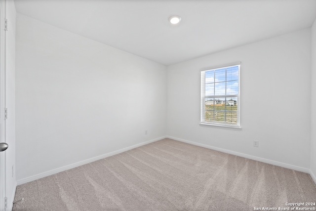 empty room featuring carpet floors and baseboards