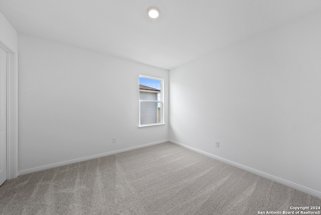 unfurnished room featuring carpet and baseboards