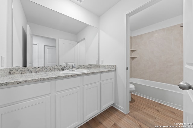 bathroom featuring vanity, bathtub / shower combination, wood finished floors, and toilet