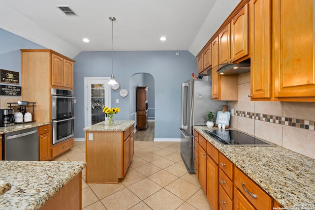 kitchen with lofted ceiling, a kitchen island, arched walkways, and stainless steel appliances