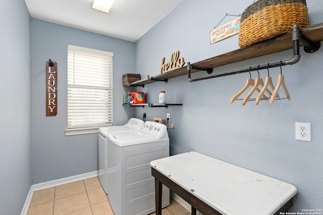 laundry area with laundry area, light tile patterned flooring, washing machine and dryer, and baseboards