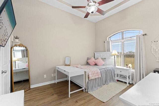 bedroom with a ceiling fan, baseboards, and wood finished floors