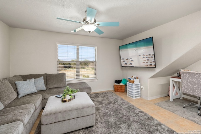 living area with ceiling fan, baseboards, a textured ceiling, and tile patterned floors