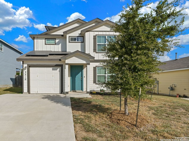 view of front of property featuring driveway, solar panels, a garage, and board and batten siding