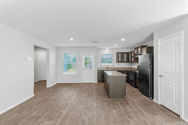 kitchen with visible vents, light wood-style floors, light countertops, black appliances, and a sink