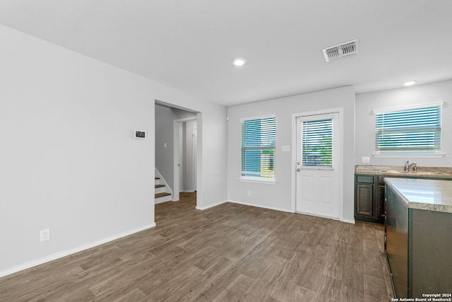 interior space featuring baseboards, stairs, visible vents, and wood finished floors