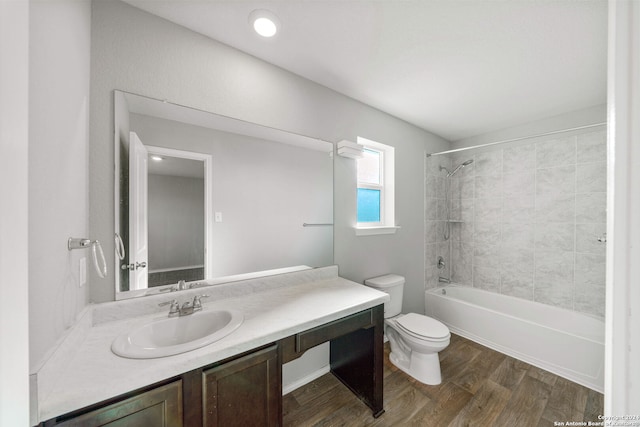 bathroom featuring washtub / shower combination, vanity, wood finished floors, and toilet