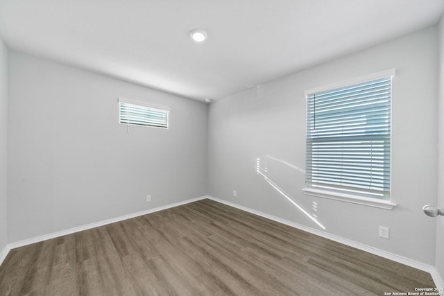 empty room featuring baseboards and wood finished floors