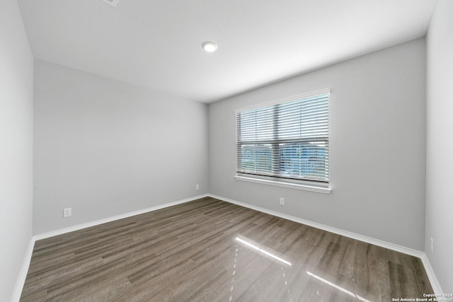 unfurnished room with baseboards and wood finished floors