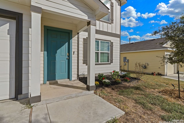 property entrance with a garage and board and batten siding